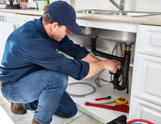 A man is Fixing Kitchen Sink