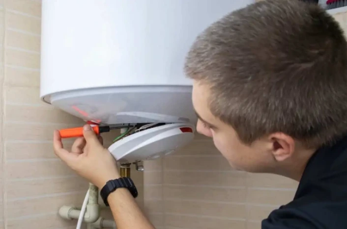 Plumber performing routine water heater maintenance in Santa Barbara home